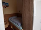 Blick auf ein Bett und einen Kleiderschrank
